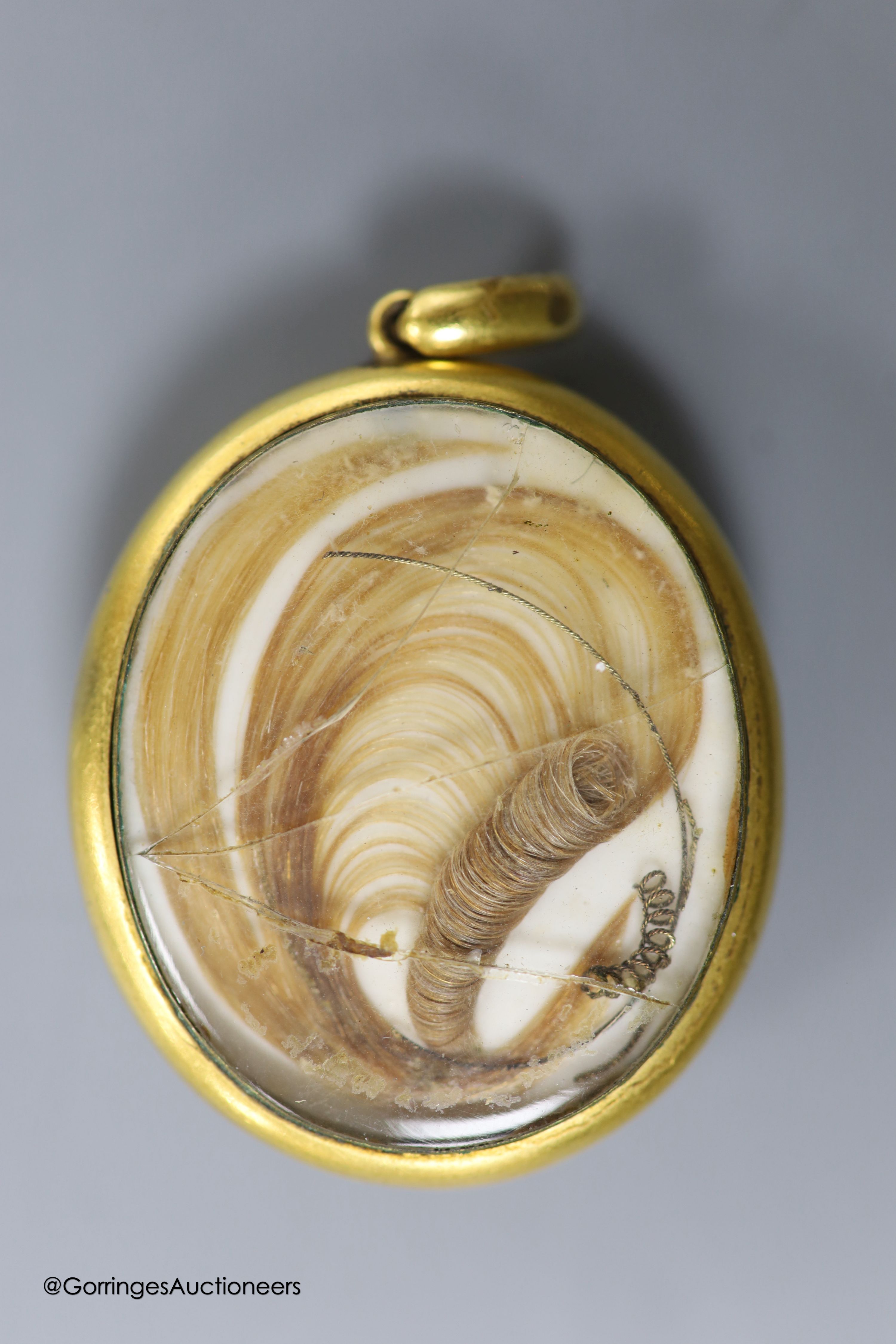 A Victorian yellow metal mounted glazed oval pendant, with miniature portrait of a young lady and plaited hair verso, 40mm, gross weight 18.1 grams, a yellow metal and tooth mounted stick pin and a gem set white metal cl